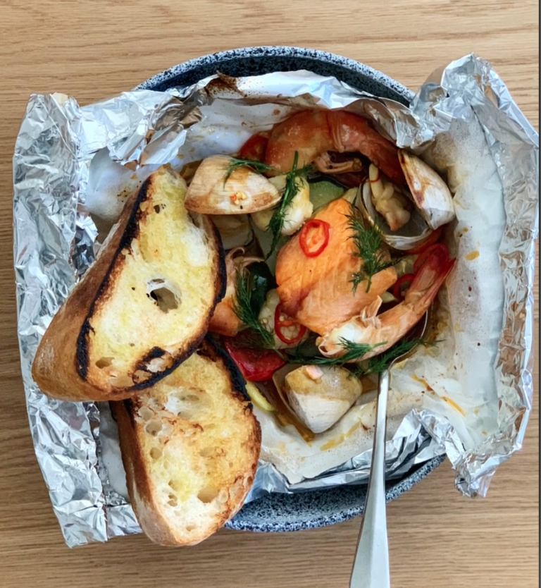 ōra King salmon and grilled bread in a unwrapped tinfoil basket